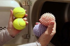 How do balls help when washing down jackets in a washing machine?
